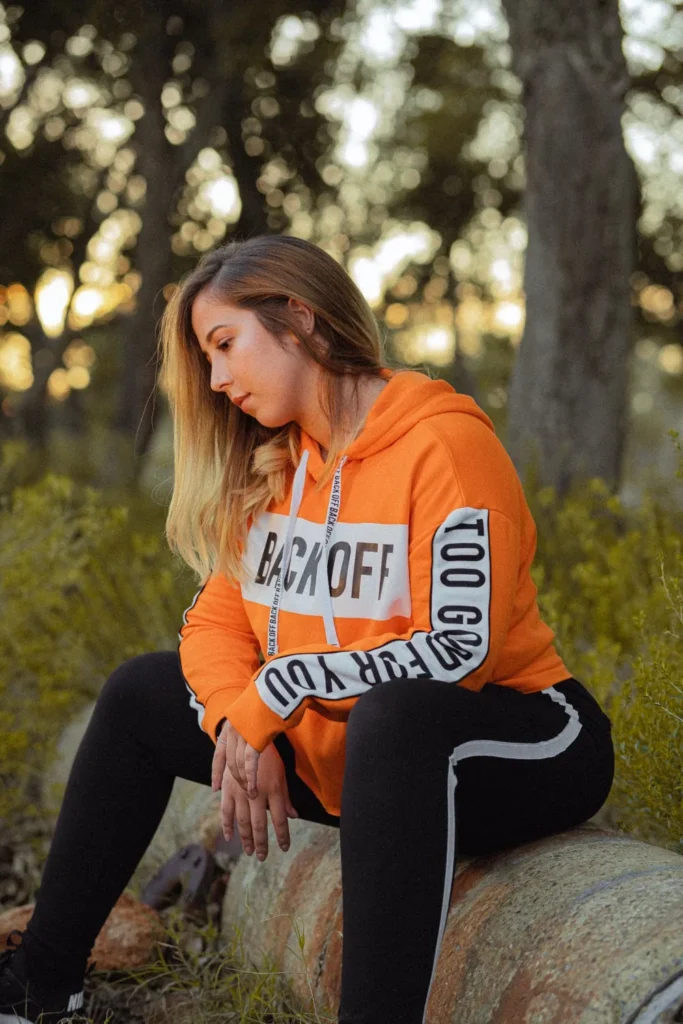 Cute Halloween hoodies for women illustrated by an orange hoodie in autumn light