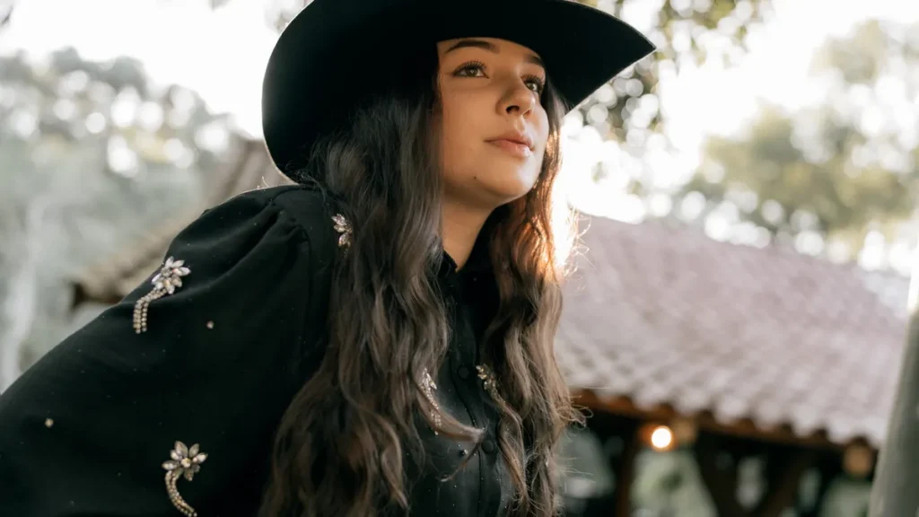 Woman in a cowboy hat inspiring western Halloween sweatshirt outfit ideas