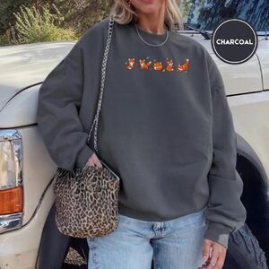 Person wearing a charcoal Autumn Foxes Embroidered Sweatshirt
