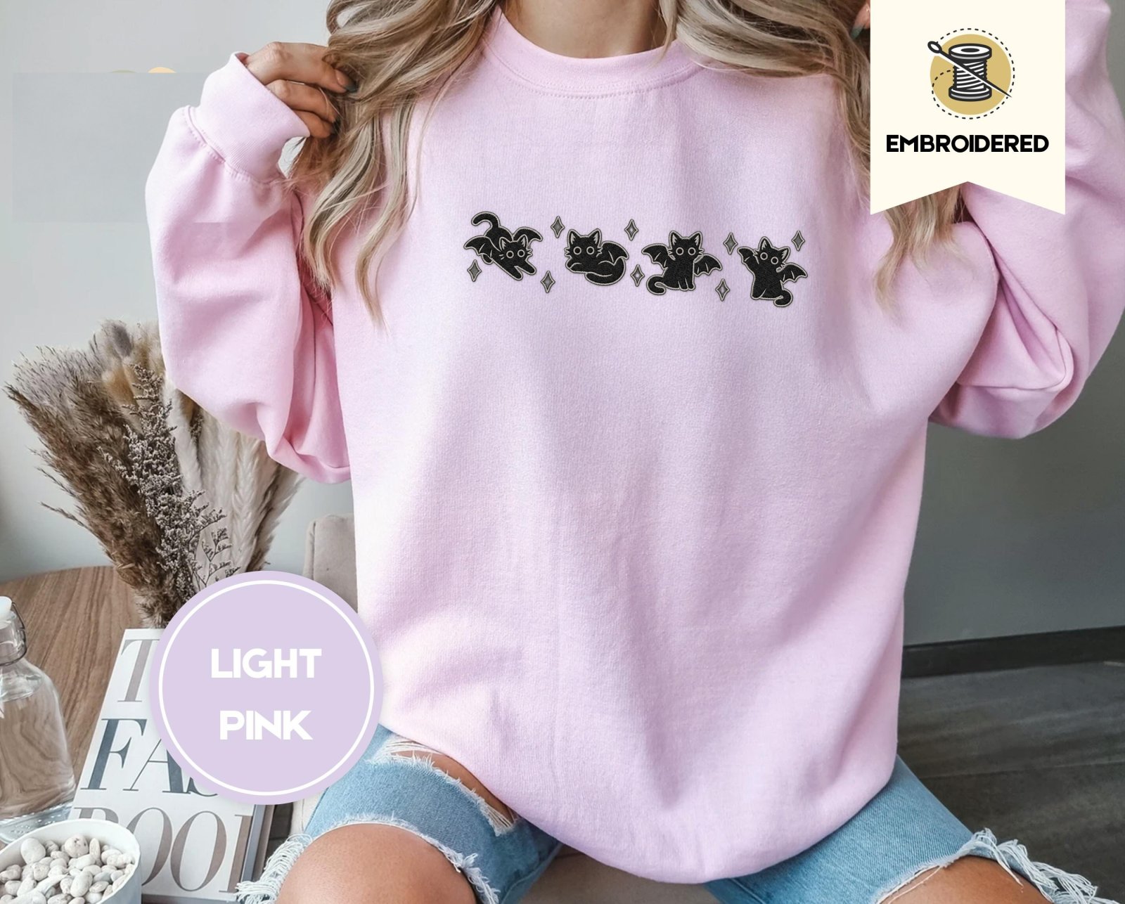 Person wearing a light pink Bat Wing Cats Embroidered Sweatshirt