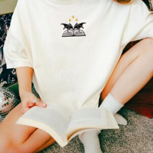 Person wearing an ivory Bat Wings and Book Embroidered T-Shirt