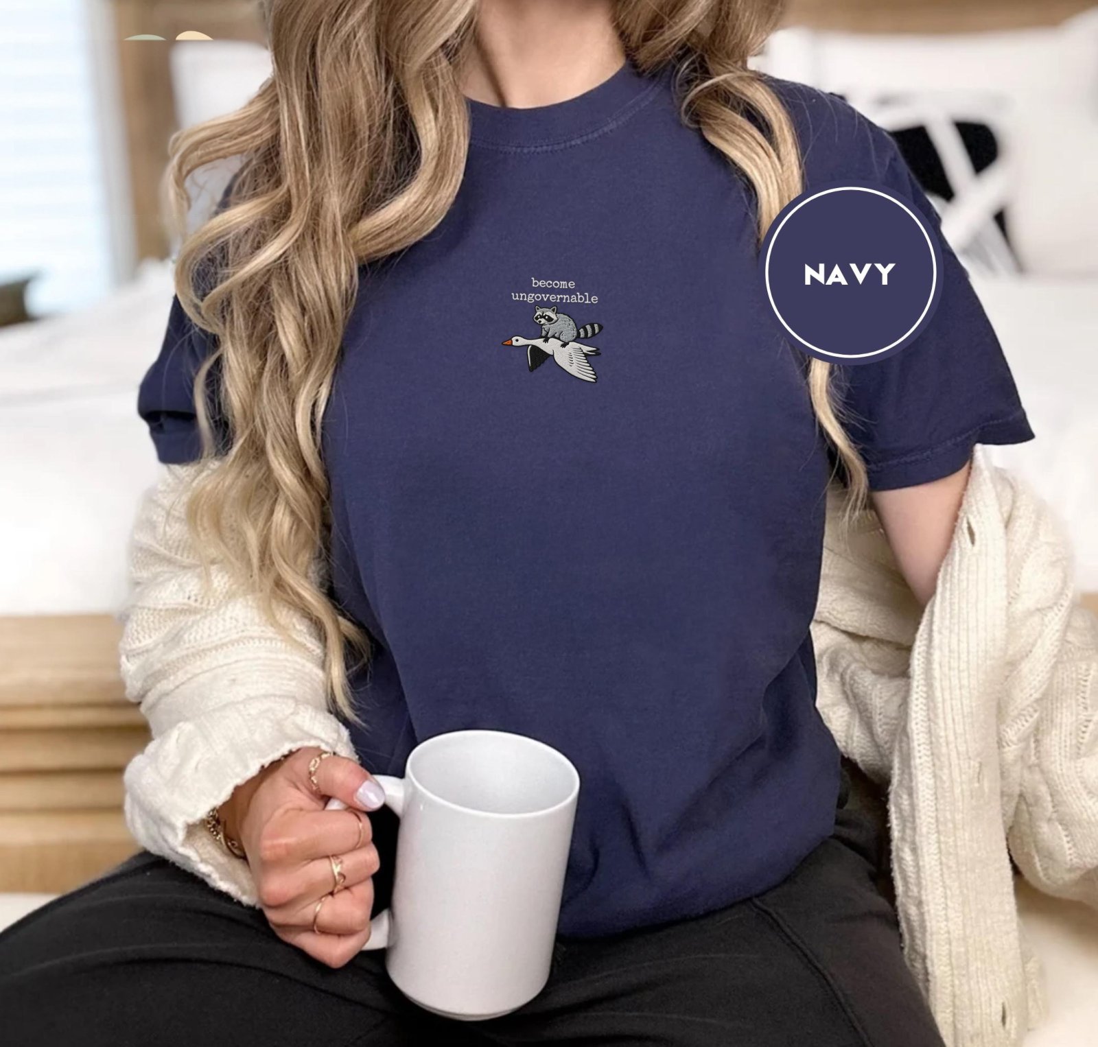 Person wearing a navy Become Ungovernable Raccoon Goose Embroidered T-Shirt