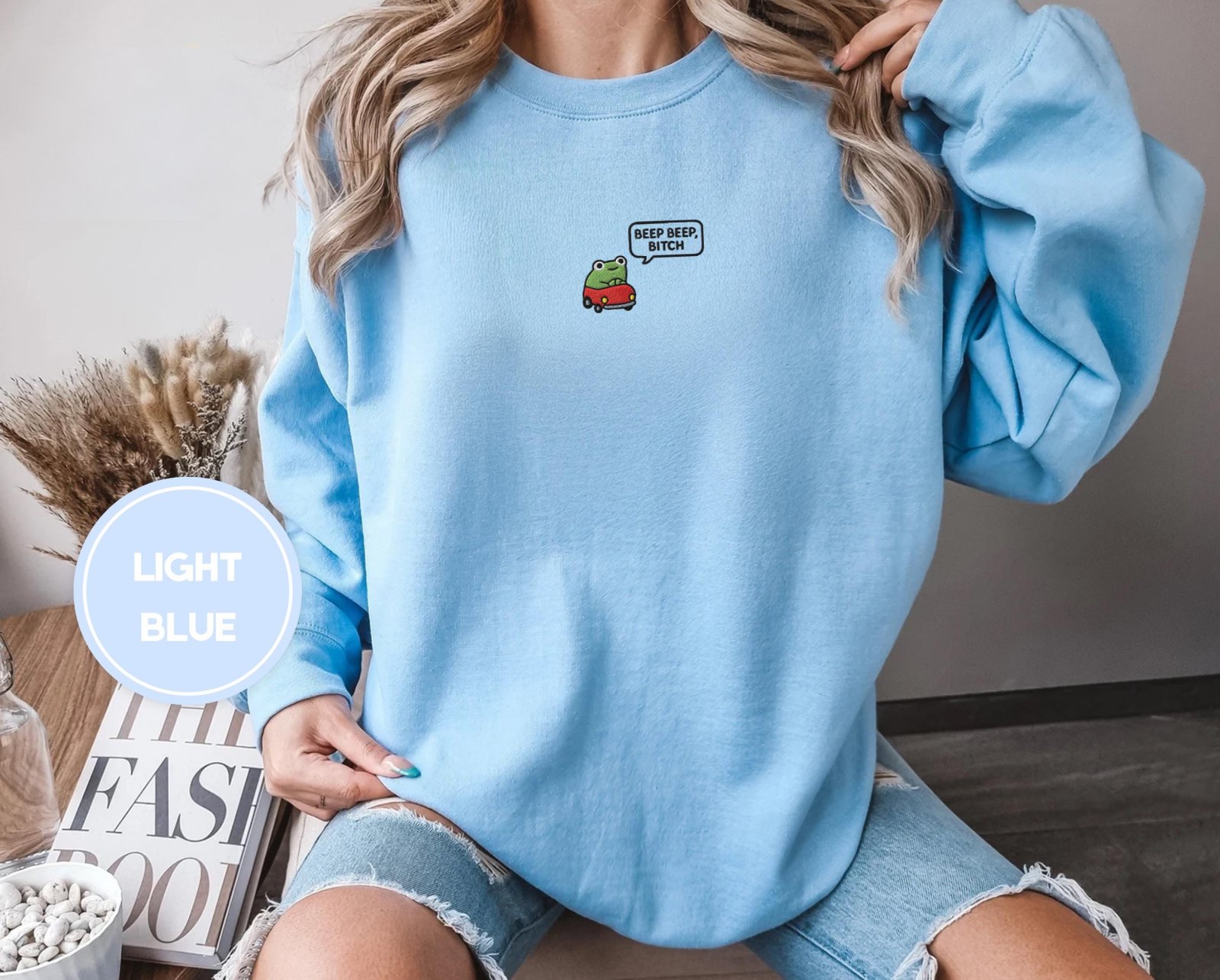Person wearing a light blue Beep Beep Frog Embroidered Sweatshirt