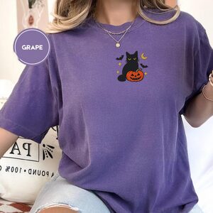 Person wearing a grape Black Cat and Pumpkin Embroidered T-Shirt