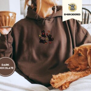 Person wearing a dark chocolate Black Cats and Fall Leaves Embroidered Hoodie