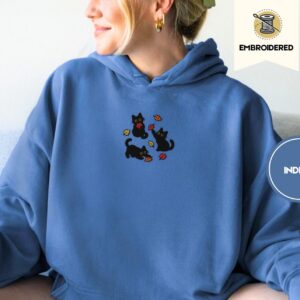 Person wearing an indigo blue Black Cats and Fall Leaves Embroidered Hoodie