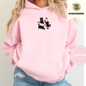 Person wearing a light pink Black Cats and Fall Leaves Embroidered Hoodie