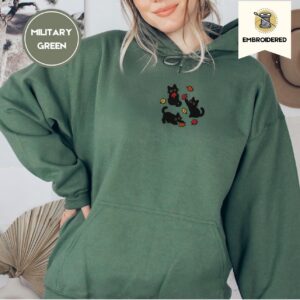Person wearing a military green Black Cats and Fall Leaves Embroidered Hoodie