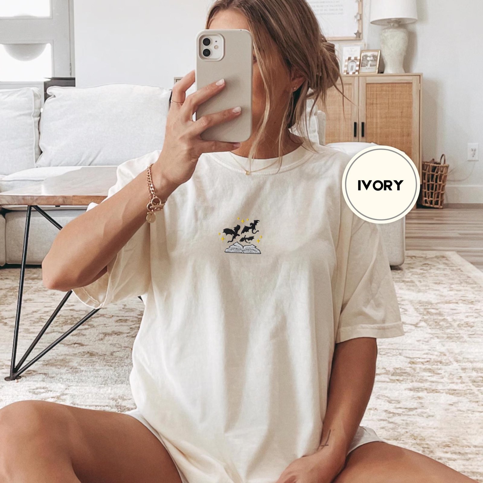 Person wearing an ivory Black Dragons and Gold Stars Embroidered T-Shirt