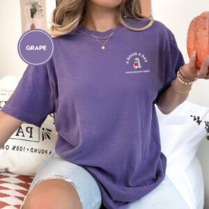 Person wearing a grape Book a Day Ghost Embroidered T-Shirt