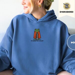 Person wearing an indigo blue Burnt Out Frog Embroidered Hoodie