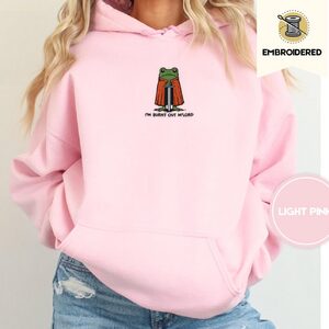 Person wearing a light pink Burnt Out Frog Embroidered Hoodie