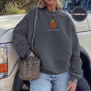 Person wearing a charcoal Burnt Out Frog Knight Embroidered Sweatshirt
