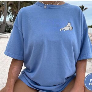 Person wearing a flo blue Cat Coffee and Books Embroidered T-Shirt
