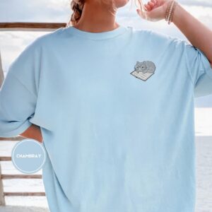 Person wearing a chambray Cat on Open Book Embroidered T-Shirt