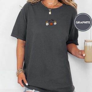 Person wearing a graphite Cowboy Ghosts and Pumpkin Embroidered T-Shirt