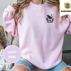 Person wearing a light pink Crow And Skull Embroidered Sweatshirt