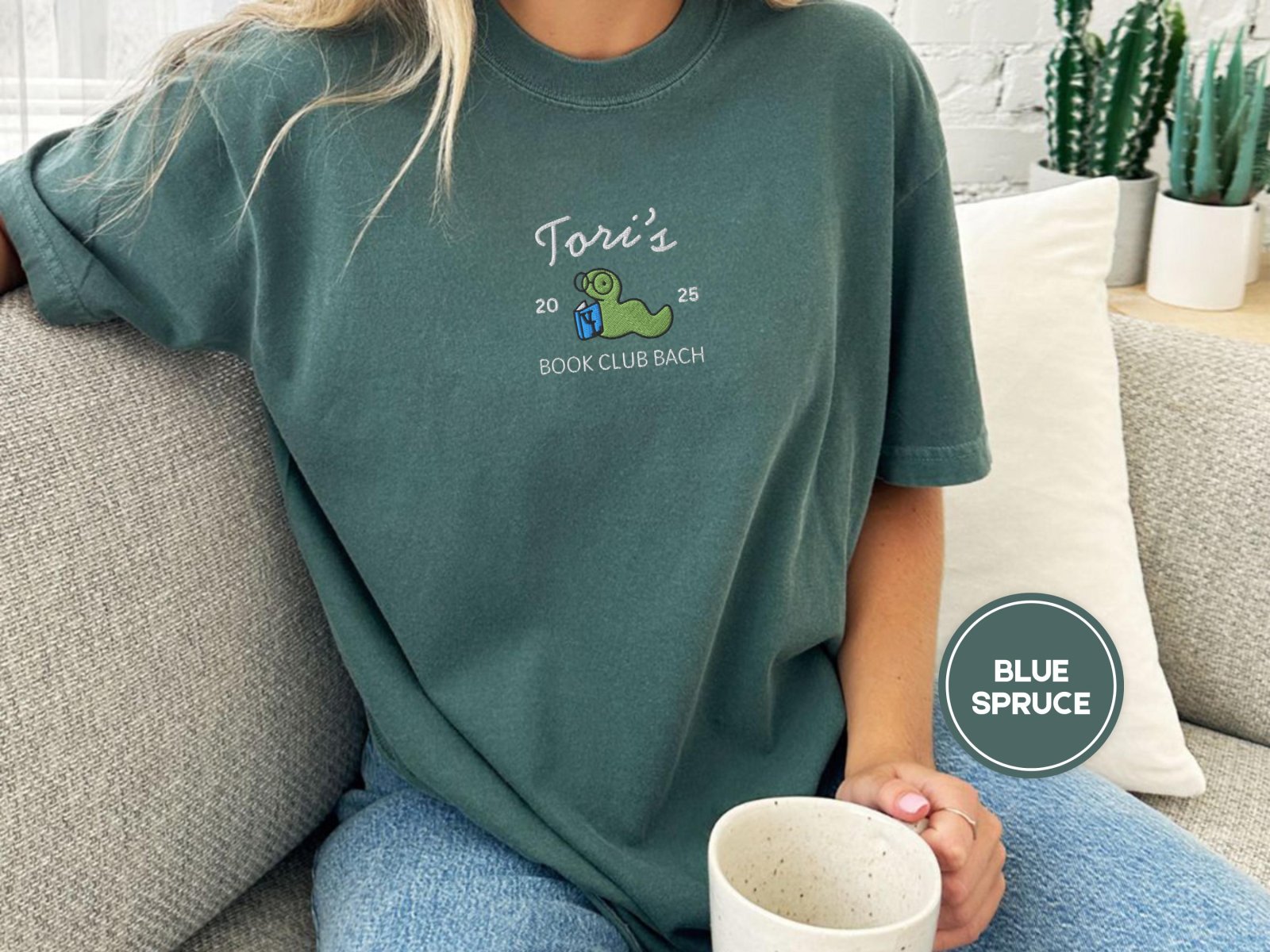 Person wearing a blue spruce Custom Bookworm Book Club Embroidered T-Shirt
