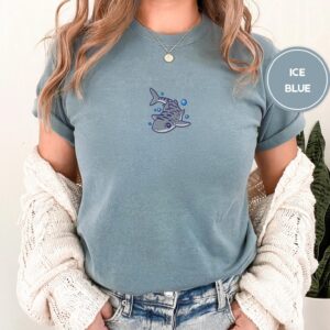 Person wearing an ice blue Cute Tiger Shark Embroidered T-Shirt