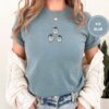 Person wearing an ice blue Dancing Penguins Embroidered T-Shirt