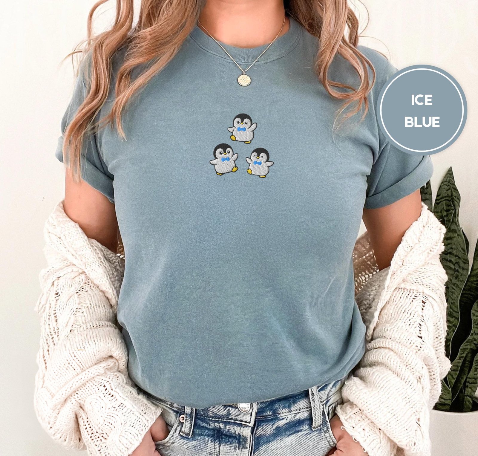 Person wearing an ice blue Dancing Penguins Embroidered T-Shirt