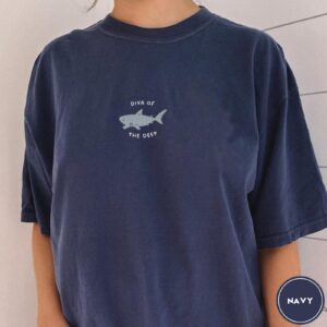 Person wearing a navy Diva Of The Deep Shark Embroidered T-Shirt