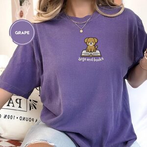 Person wearing a grape Dogs and Books Embroidered T-Shirt