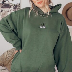 Person wearing a military green Dragons and Open Book Embroidered Hoodie