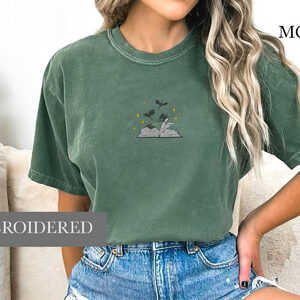 Person wearing a moss Dragons and Open Book Embroidered T-Shirt
