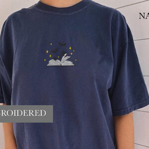 Person wearing a true navy Dragons and Open Book Embroidered T-Shirt