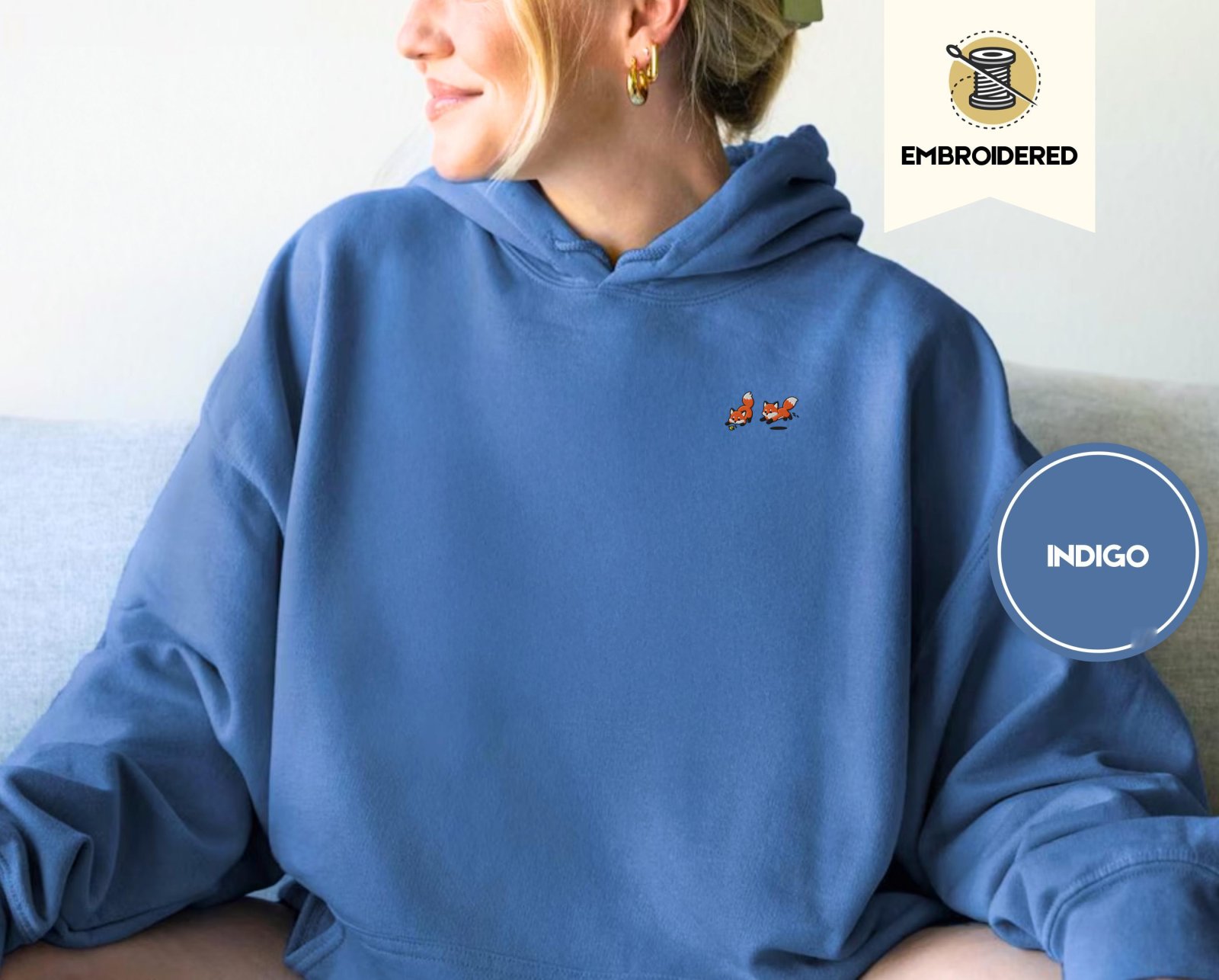 Person wearing an indigo blue Five Playful Foxes Embroidered Hoodie