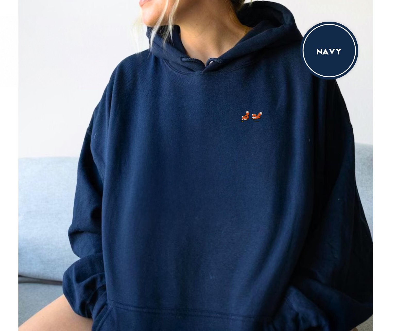 Person wearing a navy Five Playful Foxes Embroidered Hoodie