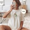Person wearing an ivory Frog and Butterfly Embroidered T-Shirt
