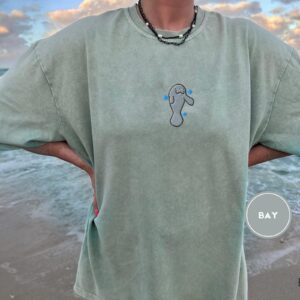 Person wearing a bay Gentle Manatee Embroidered T-Shirt