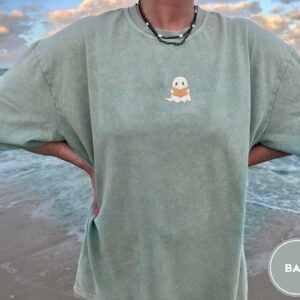 Person wearing a bay Ghost Reading a Book Embroidered T-Shirt