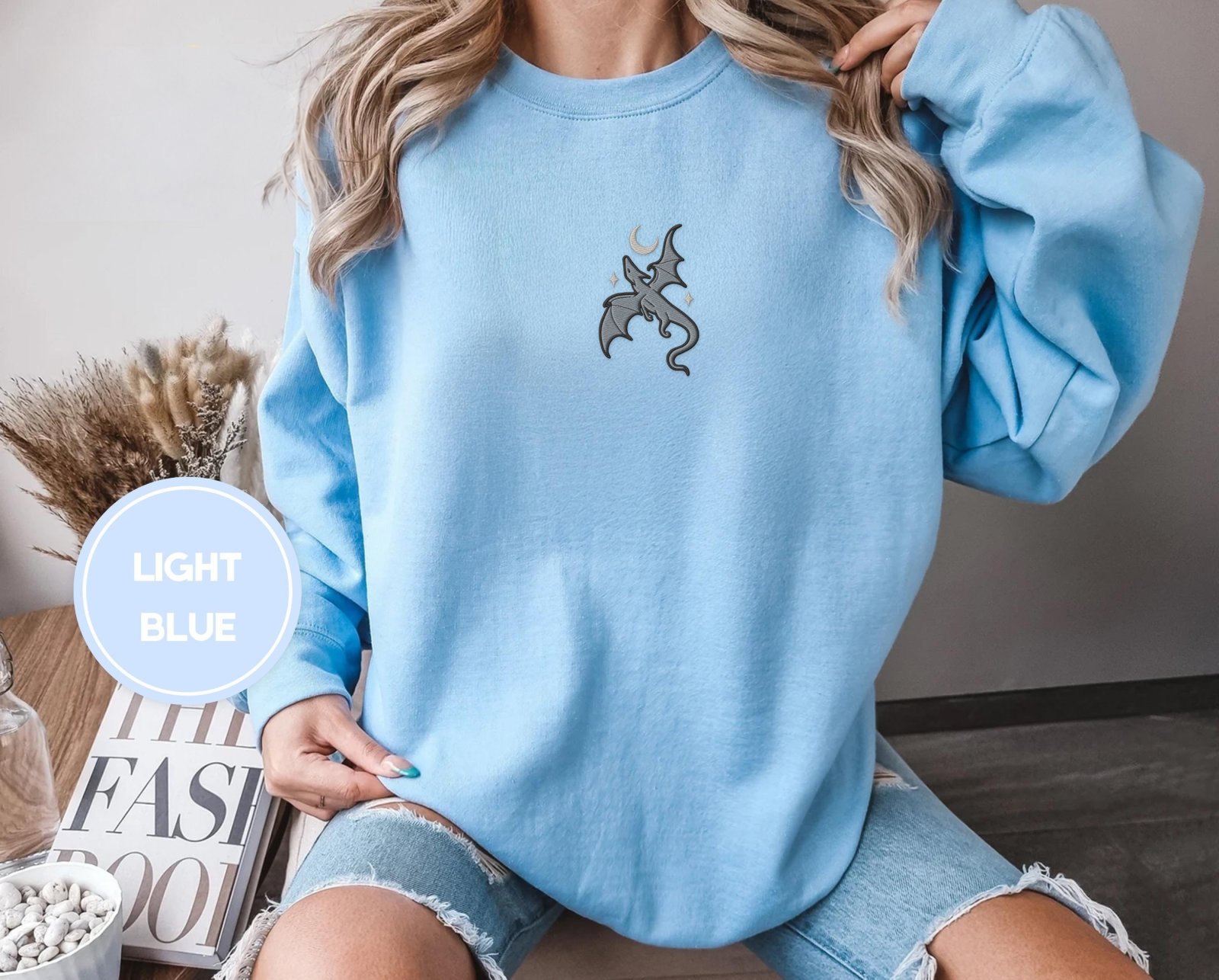 Person wearing a light blue Gray Dragon and Stars Embroidered Sweatshirt