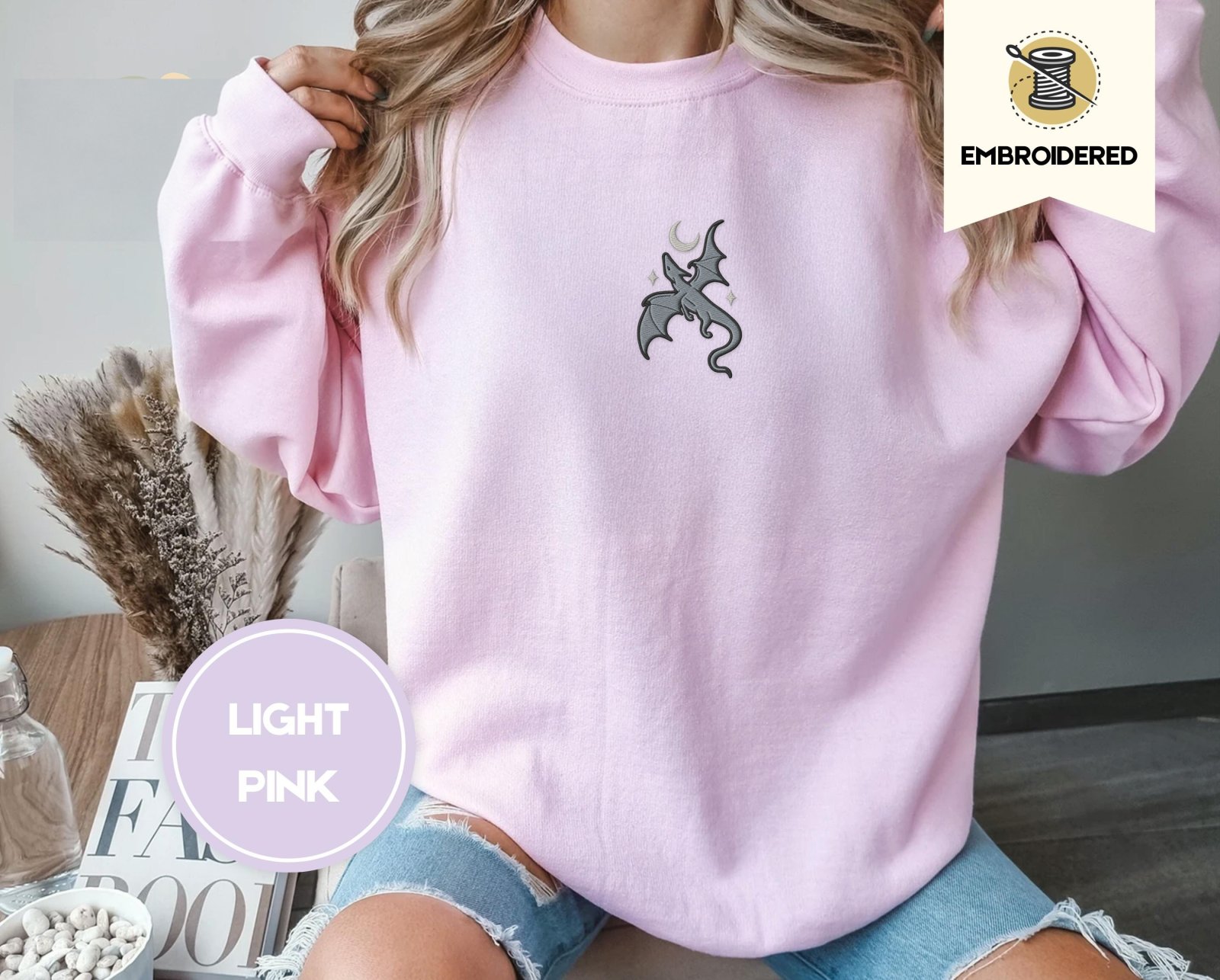 Person wearing a light pink Gray Dragon and Stars Embroidered Sweatshirt