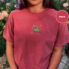 Person wearing a brick Green Frog and Golden Stars Embroidered T-Shirt