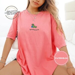 Person wearing a watermelon Green Worm Blue Book Embroidered T-Shirt