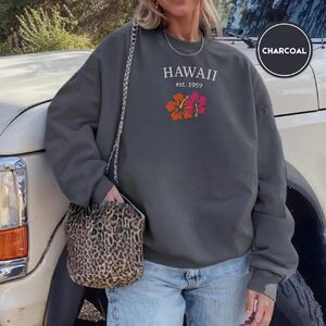Person wearing a charcoal Hawaii Hibiscus Embroidered Sweatshirt