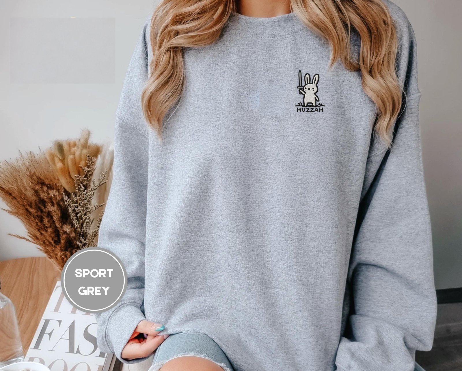 Person wearing a sport grey Huzzah Sword Bunny Embroidered Sweatshirt