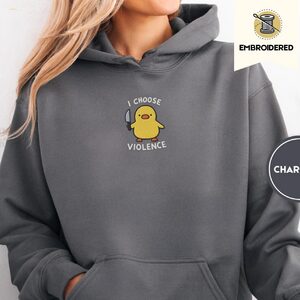 Person wearing a charcoal I Choose Violence Duck Embroidered Hoodie