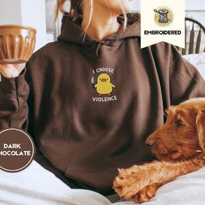 Person wearing a dark chocolate I Choose Violence Duck Embroidered Hoodie