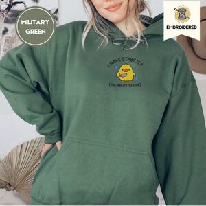 Person wearing a military green I Have Stability Duck Embroidered Hoodie