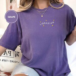 Person wearing a grape Librarian Stars Embroidered T-Shirt