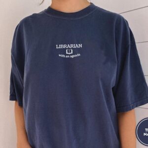 Person wearing a true navy Librarian With An Agenda Embroidered T-Shirt