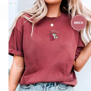 Person wearing a brick Meowdy Cowboy Cat and Shrimp Embroidered T-Shirt