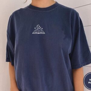 Person wearing a true navy Moonlit Mountain Book Embroidered T-Shirt