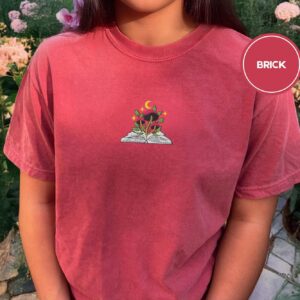 Person wearing a brick Mushroom and Moon Book Embroidered T-Shirt