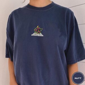 Person wearing a true navy Mushroom and Moon Book Embroidered T-Shirt